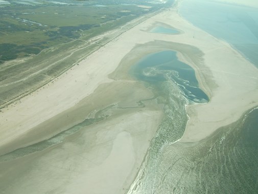 De zandmotor bij Den Haag. De Zandmotor is niet enkel een stuk strand. Het is een opgespoten strand dat ook functioneert als kustverdediging. Er spoelen regelmatig archeologisch relevante objecten aan. (Foto: Wikipedia)