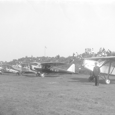 Op een mooie zondag in augustus 1934 landden maar liefst 15 sportvliegtuigen op het vliegveld, als tussenstop tijdens een rondvlucht boven Nederland. Het internationale gezelschap vliegers kwam uit Duitsland, België, Frankrijk, Hongarije en Oostenrijk. Nadat ze gastvrij waren ontvangen door M.A.G. van der Leeuw, vertrok de groep weer. (Foto: Streekarchief Voorne-Putten)