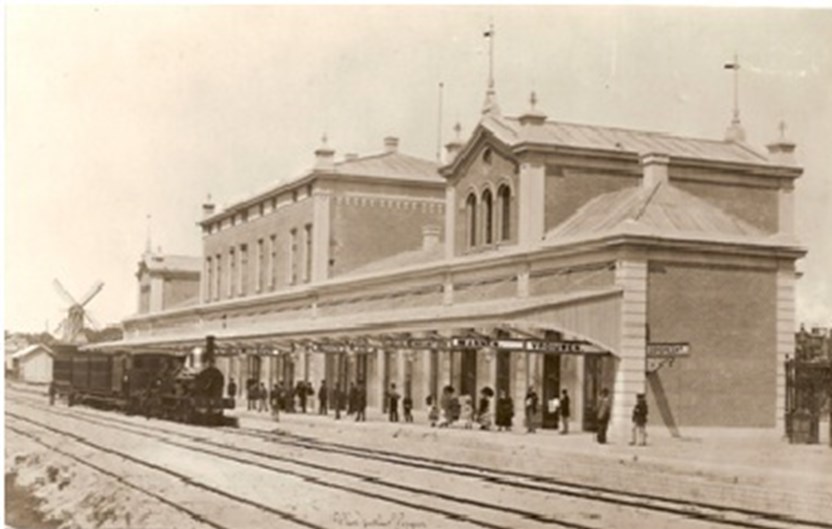Een historische afbeelding van een trein die het station benaderd