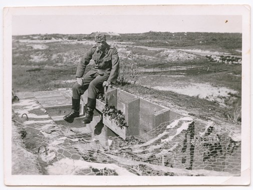 Bij Hoek van Holland werden ook bloembakken in de toegangen van bunkers aangelegd. De militair poseert niet alleen bij de ingang, maar maakte ook nog een detailfoto van de bakken.