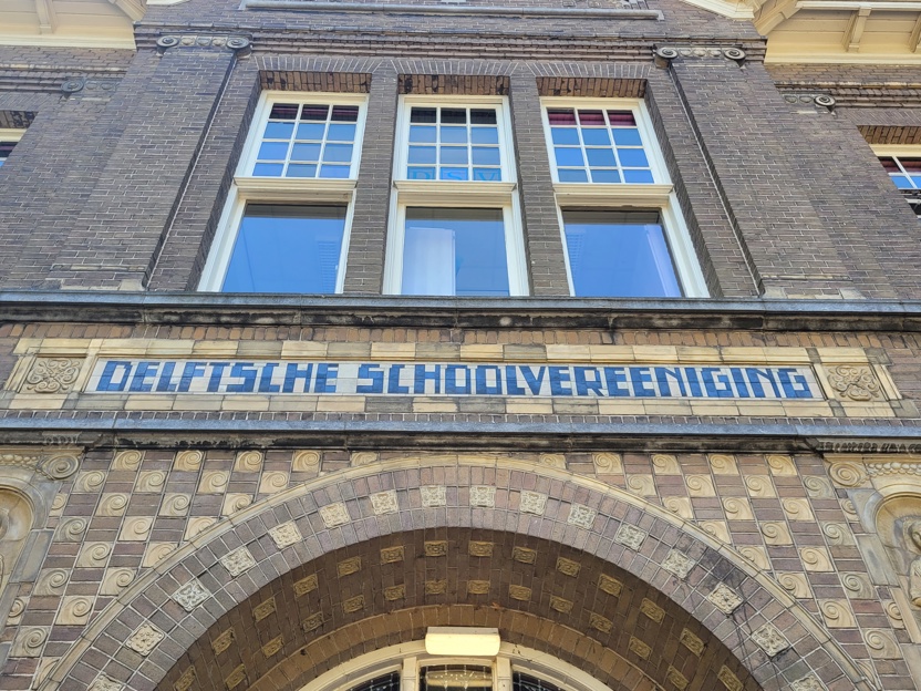 Detail van Delftsche Schoolvereeniging boven de ingang 