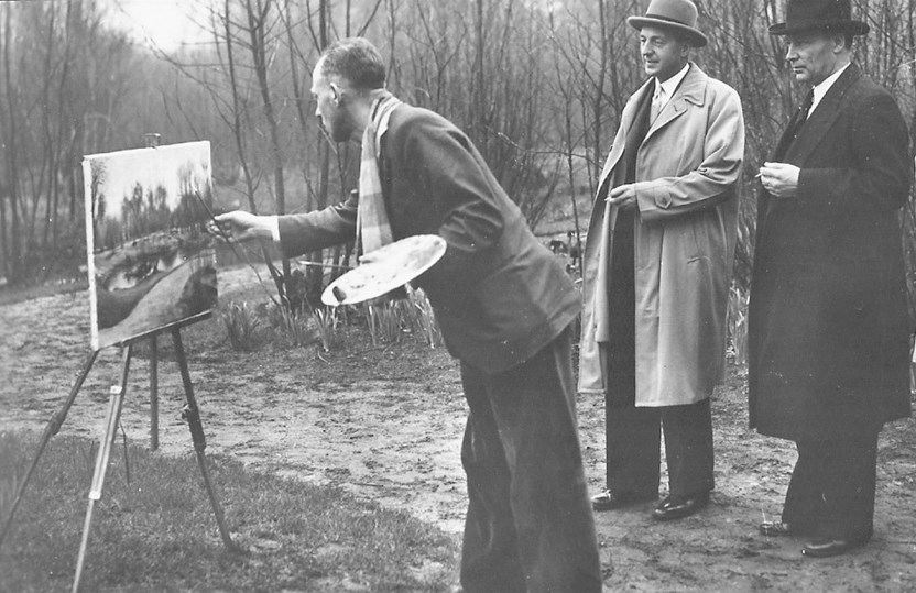 Mansholt (midden), minister van Landbouw, Visserij en Voedselvoorziening, bekijkt samen met Tom van Waveren, voorzitter van de Keukenhof, hoe kunstenaar Jos van Driel het landschap vastlegt. Foto: Bloemen-tentoonstelling Keukenhof, 23 maart 1950. 